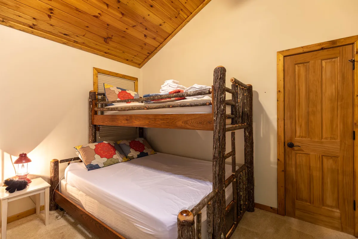 A charming bunk bed nook, complete with decorative pillows and a lantern-lit nightstand. The space feels both playful and intimate, perfect for family bonding or cozy storytelling sessions at the end of an adventurous day.