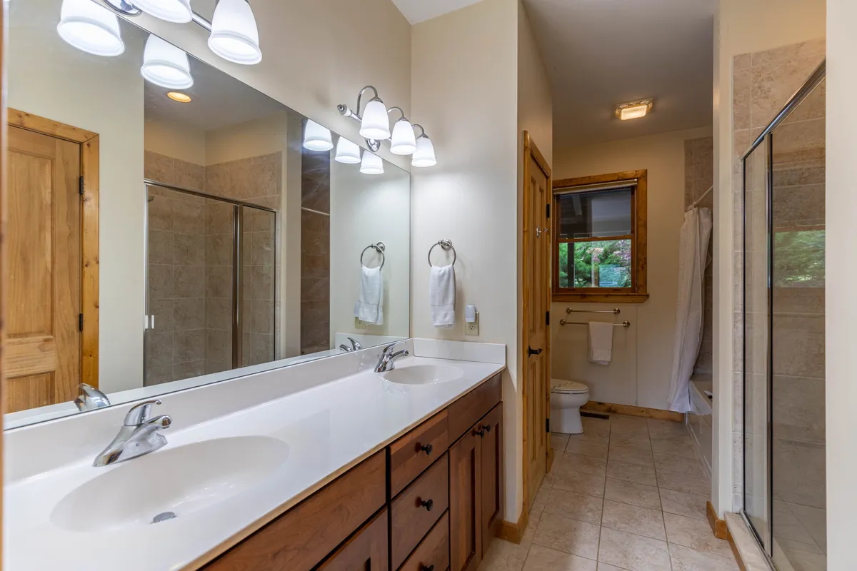 A serene bathroom space featuring a double vanity with large mirrors and a walk-in shower. The inviting setup is ideal for morning routines and moments of self-care.